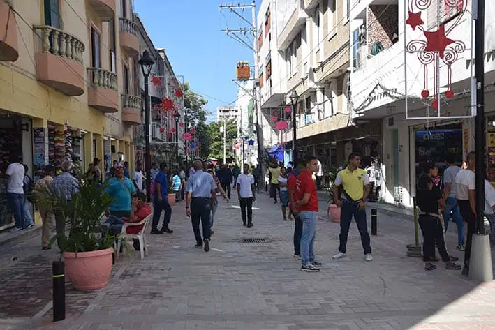 Pedestrian street with many people walking and looking at the shops lining the walkway