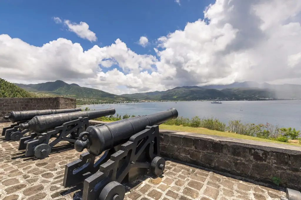 Three old cannons set behind a stone wall facing the water in the event of an attack.