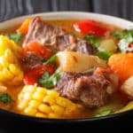 Bowl of soup filled with beef, corn, sweet potato