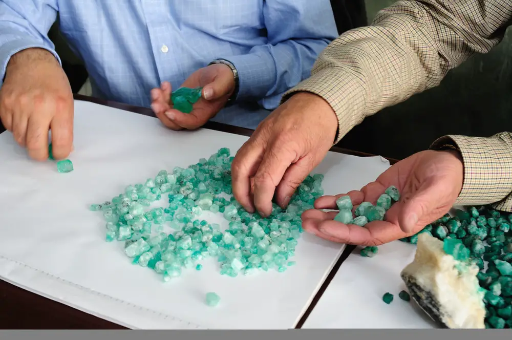 two people sorting colombian emeralds