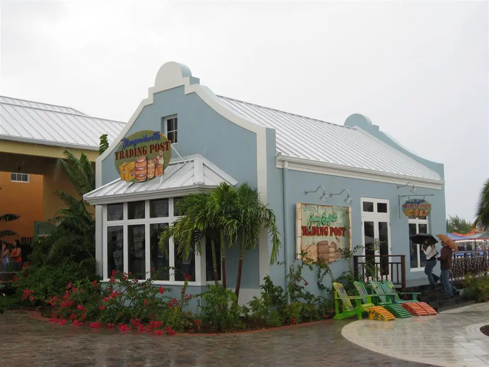 Small light blue building with white roof and trim with sign - Margaritaville's Trading Post