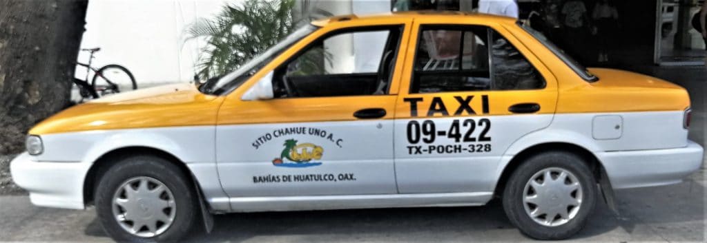 A taxi cab. White is on the bottom and yellow is on the top. It is labelled with a taxi number and company logo. 