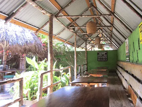 Inside of Scotchies restaurant - small space with open wall, few tables and hut-like roof