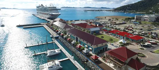 Aerial view of Tortola Pier Park, the cruise terminal in Tortola. Pier buildings are in the foreground with a docked cruise ship and town in background