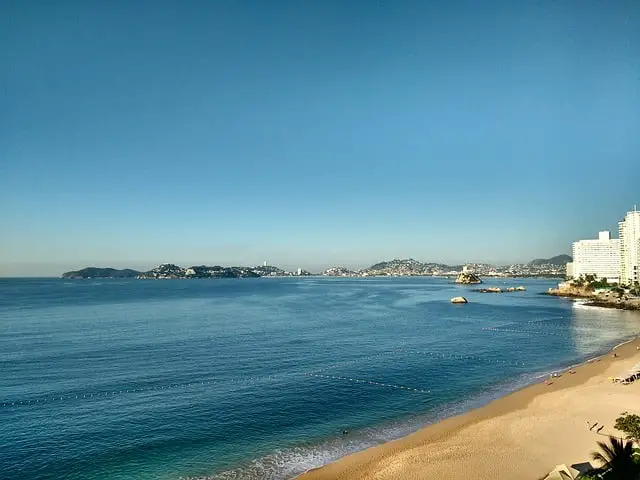 Wide view of the buildings of Acapulco, the beach, and the ocean
