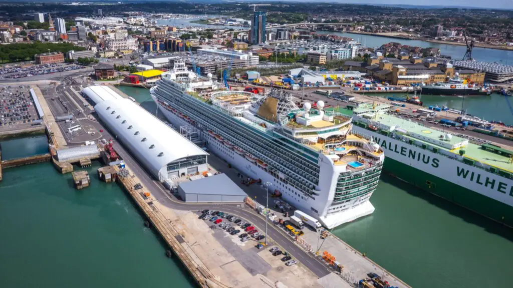 Aerial view of cruise ship docked at Ocean Cruise Terminal in Southampton. England. It is surrounded by cargo areas with the city in the background.