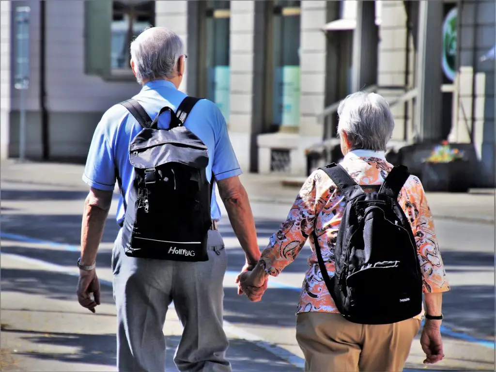 Senior couple wearing back packs