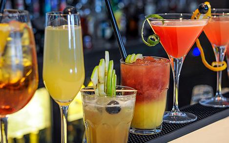 different cocktails lined up on a bar