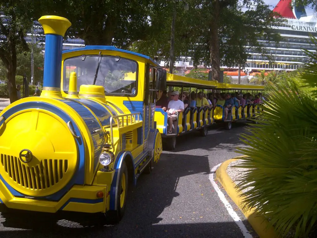 Yellow and blue Chu chu tourist trolley-train which runs on wheels, with open air cars pulled by an "engine."