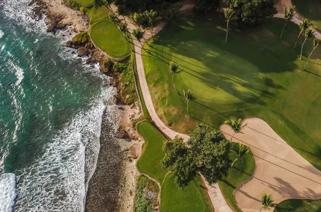 Aerial view of green golf hole along the ocean shoreline at Teeth of the Dog golf course at Casa de Campo.
